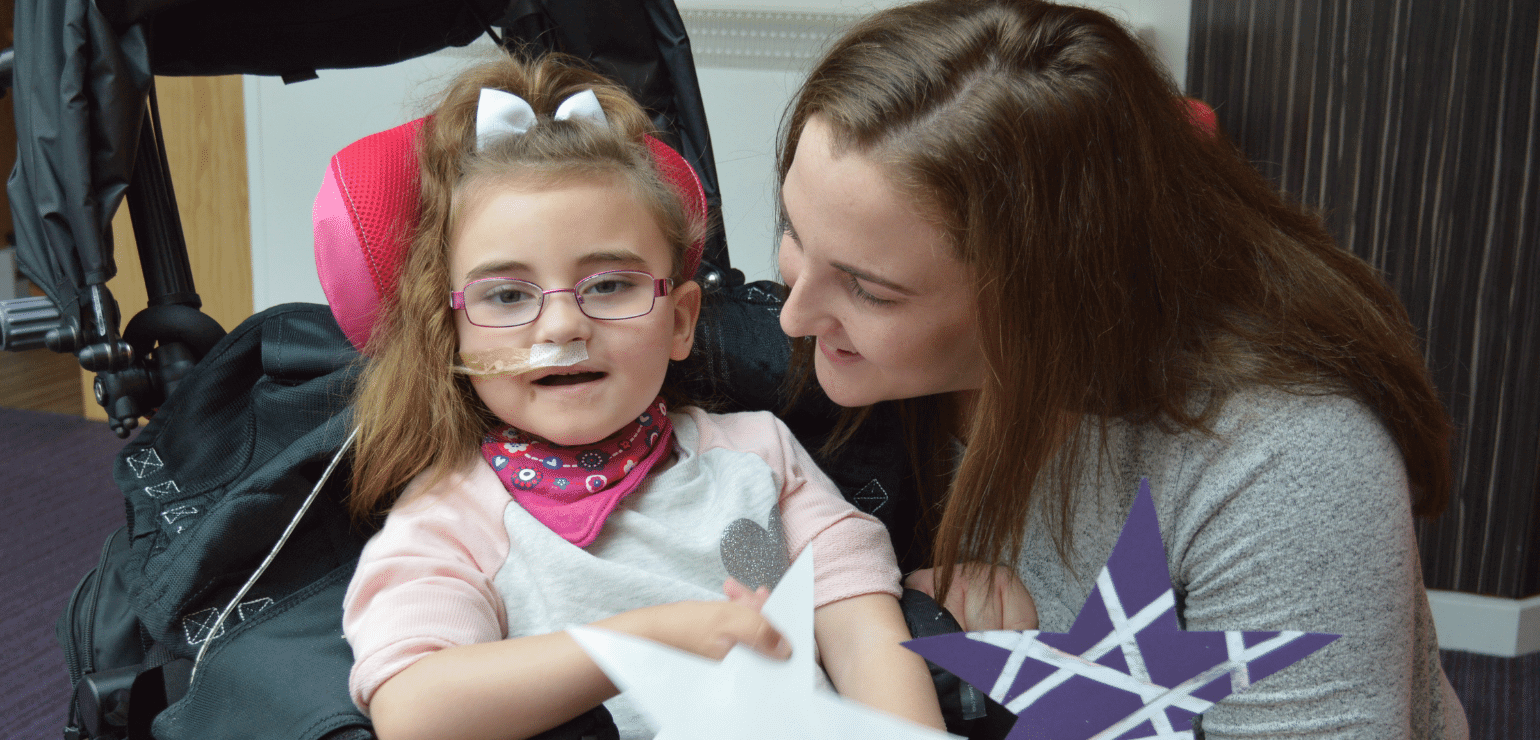 Little girl smiling with her mum at the hospice