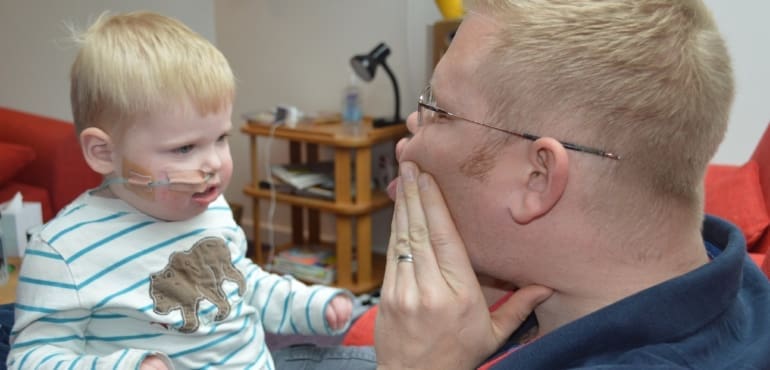Little boy with his dad smiling at the hospice