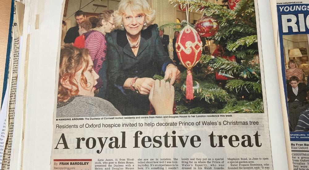 Camilla with child putting decoration on christmas tree