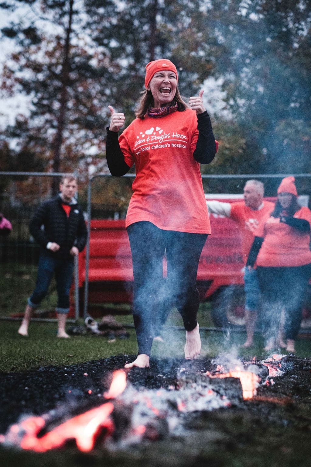 A woman smiling as she walks over hot coals